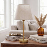 Lámpara decorativa MARGOT WOOD AND GOLD en sala luminosa con sofá y flores secas