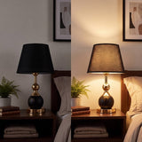 Lámpara decorativa VENUS BLACK AND GOLD en sala luminosa con sillón beige