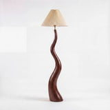 Luminaria de pie escultural con silueta sinuosa y estilo biofílico para interiorismo residencial.