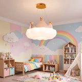 Lámpara colgante de nube con corona en dormitorio infantil con mural de arcoíris.
