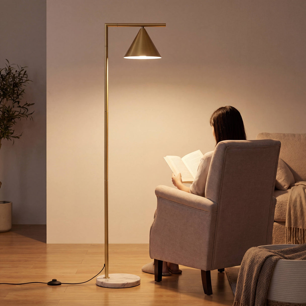 Mujer leyendo en sillón orejero iluminada por lámpara de pie de diseño minimalista.