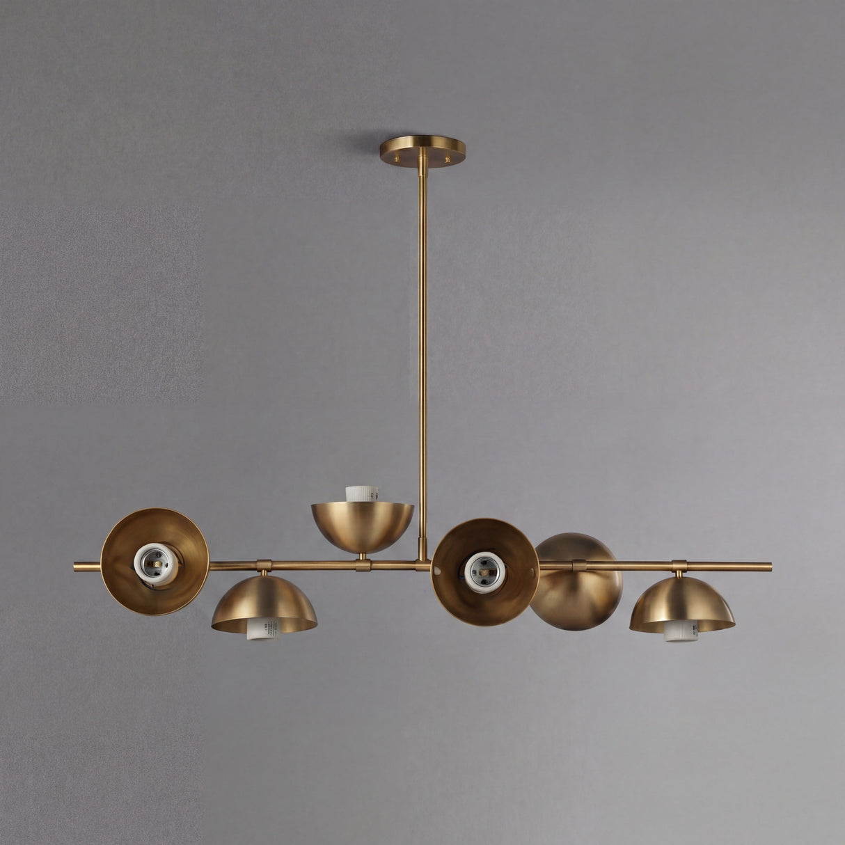 Vista frontal de la lampara lineal Nova Gold sobre un fondo gris minimalista.