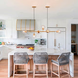 Modelo Amber Line Gold aportando sofisticación sobre una isla de cocina blanca de concepto abierto.