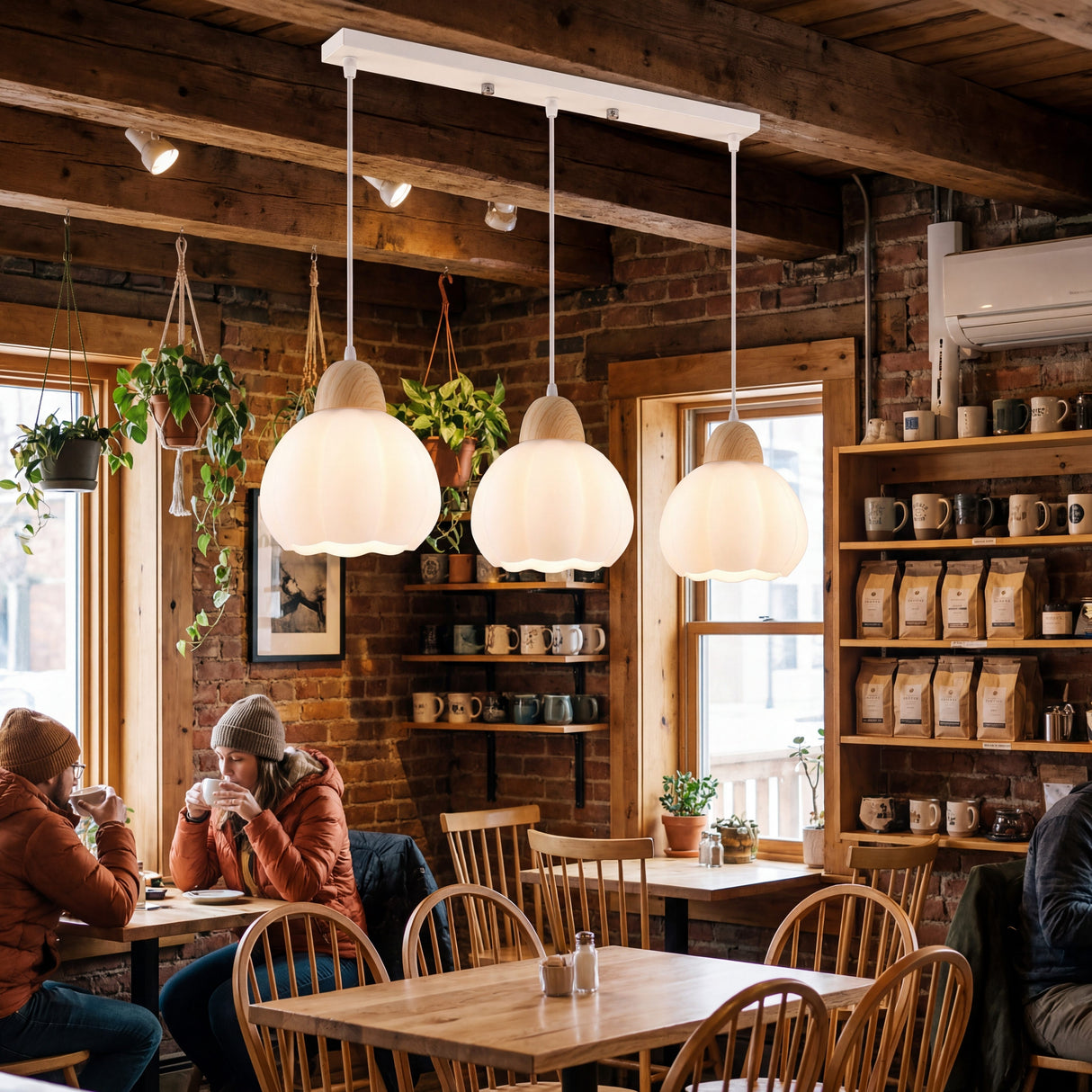 Lámpara triple sobre mesas de restaurante con paredes de ladrillo y madera.