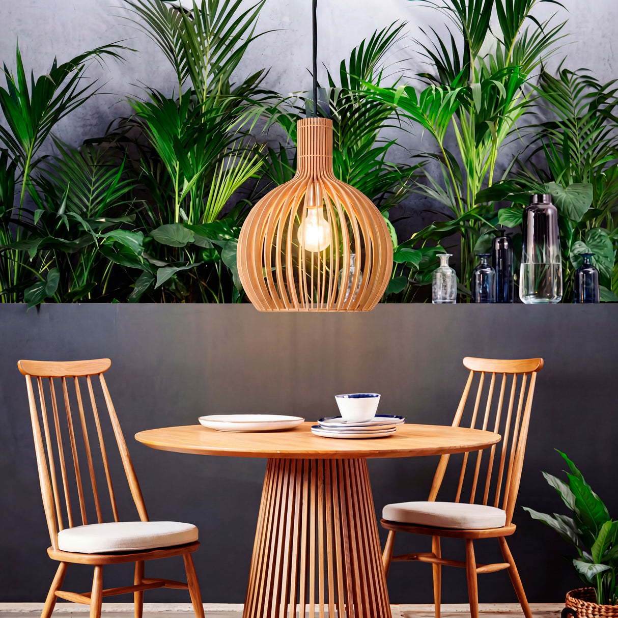 Lámpara Francisca Wood integrada en una sala comedor con abundante vegetación.