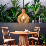 Lámpara Francisca Wood integrada en una sala comedor con abundante vegetación.
