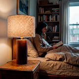 Punto de luz para lectura nocturna sobre mesilla de noche en habitación contemporánea.