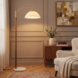 Lámpara de arco con pantalla plisada blanca, cuerpo de madera y base de mármol en salón de diseño clásico contemporáneo.
