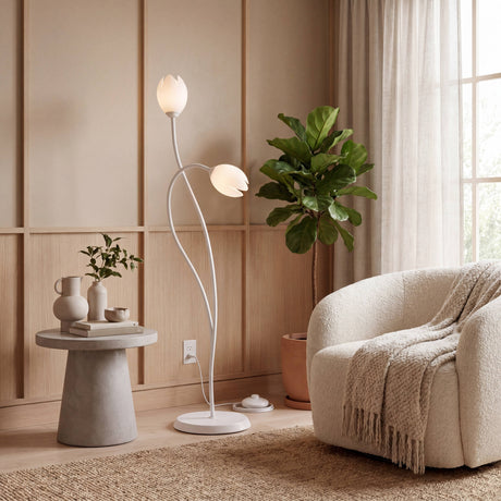 Iluminación técnica de pie con doble difusor floral en salón minimalista de tonos neutros.