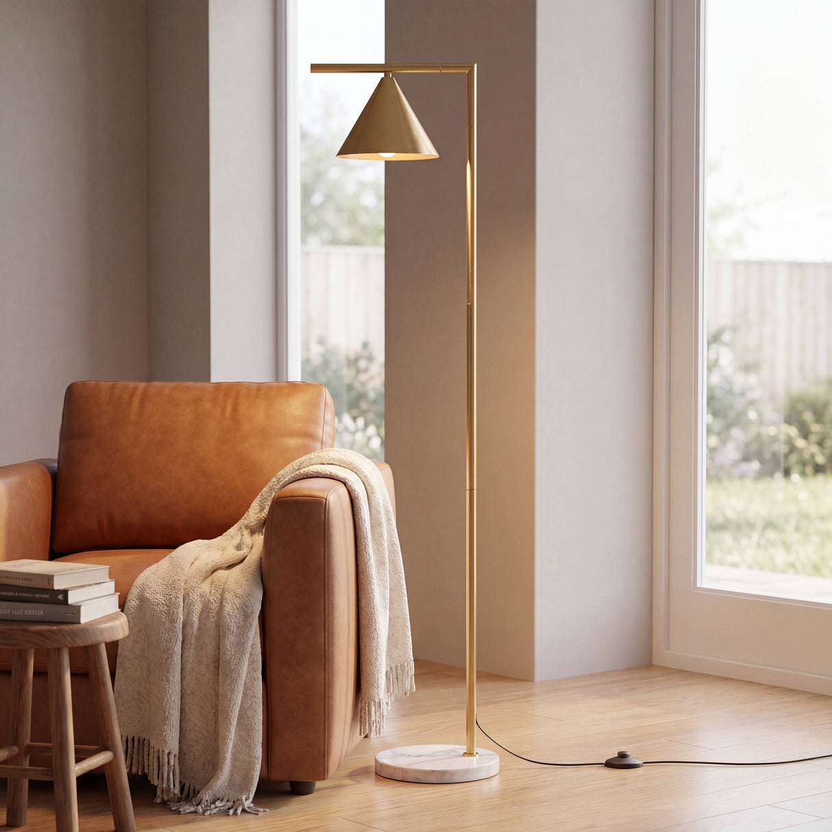 Rincón de lectura con sillón de cuero y lámpara de pie dorada de diseño nórdico.