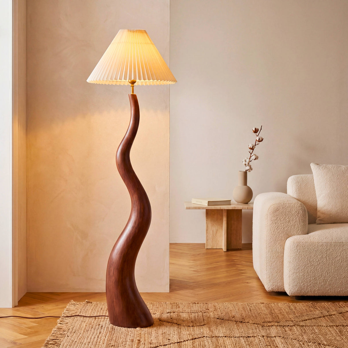 Lámpara de pie escultural en madera oscura con base ondulada y pantalla plisada en salón minimalista cálido.