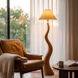 Iluminación técnica residencial en salón moderno con luminaria vertical de mástil curvado en acabado madera natural.