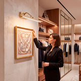 Aplique Johana iluminando un cuadro decorativo en un vestidor de lujo con luz cálida.