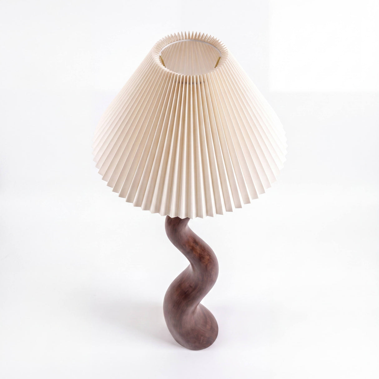 Lámpara de sobremesa con base curva de madera y pantalla plisada para iluminación de acento.