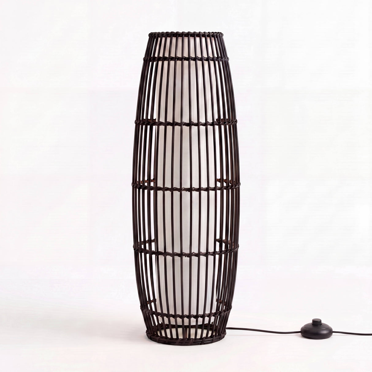 Estructura elíptica exenta de diseño minimalista con entramado oscuro sobre fondo blanco neutro.