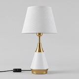 Lámpara de velador AMIRA WHITE AND GOLD con luz cálida en mesa de noche de noche