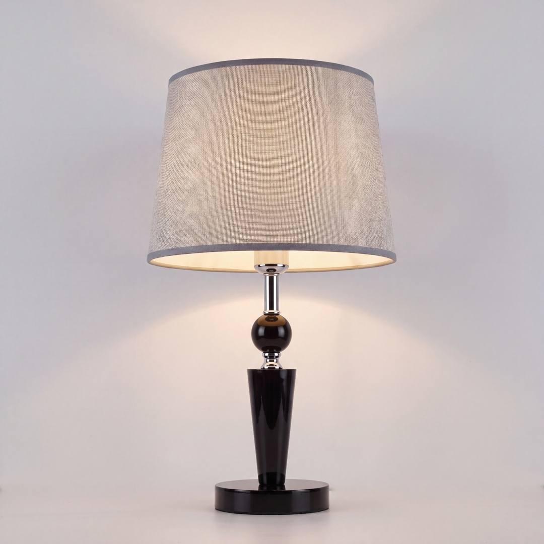 Lámpara de velador negra encendida sobre la mesa de noche