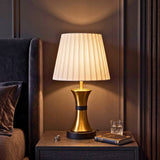 Lámpara de velador COCO GOLD AND BLACK con luz cálida en ambiente oscuro
