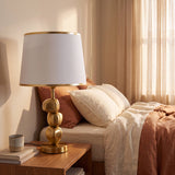 Lámpara de velador PIETRA GOLD dorada sobre mesa de noche en dormitorio acogedor