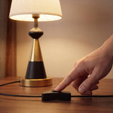 Mano encendiendo la lámpara con el interruptor en línea del cable