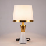 Lámpara de velador CLEO GOLD blanca encendida de noche con luz cálida ambiental