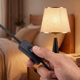 Luz cálida de la lámpara de velador AURELIA iluminando dormitorio acogedor