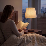 Lámpara de velador NORA WALNUT iluminando la lectura nocturna en el dormitorio
