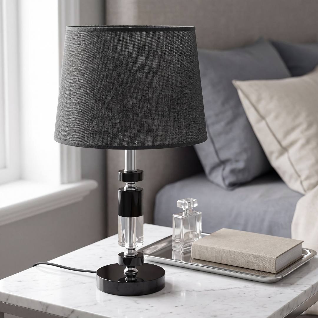 Lámpara de velador negra sobre mesa de noche junto a la cama