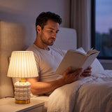 Lámpara de velador PERLA CREAM AND GOLD iluminando la lectura nocturna en la cama