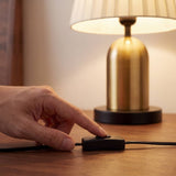 Mano encendiendo la lámpara con el interruptor en línea del cable