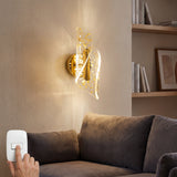 Lampara de pared Vortex Nebula Gold instalada de forma vertical en una sala moderna sobre un sofa gris.