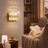 Lámpara de pared Wave Gold LED en dormitorio moderno junto a persona leyendo.