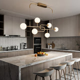 Lampara colgante de 6 globos instalada sobre isla de cocina con acabados de marmol.