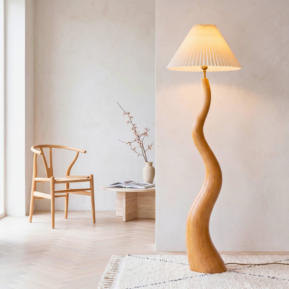 Luminaria de diseño orgánico en madera clara texturizada y pantalla cónica plisada junto a silla nórdica.