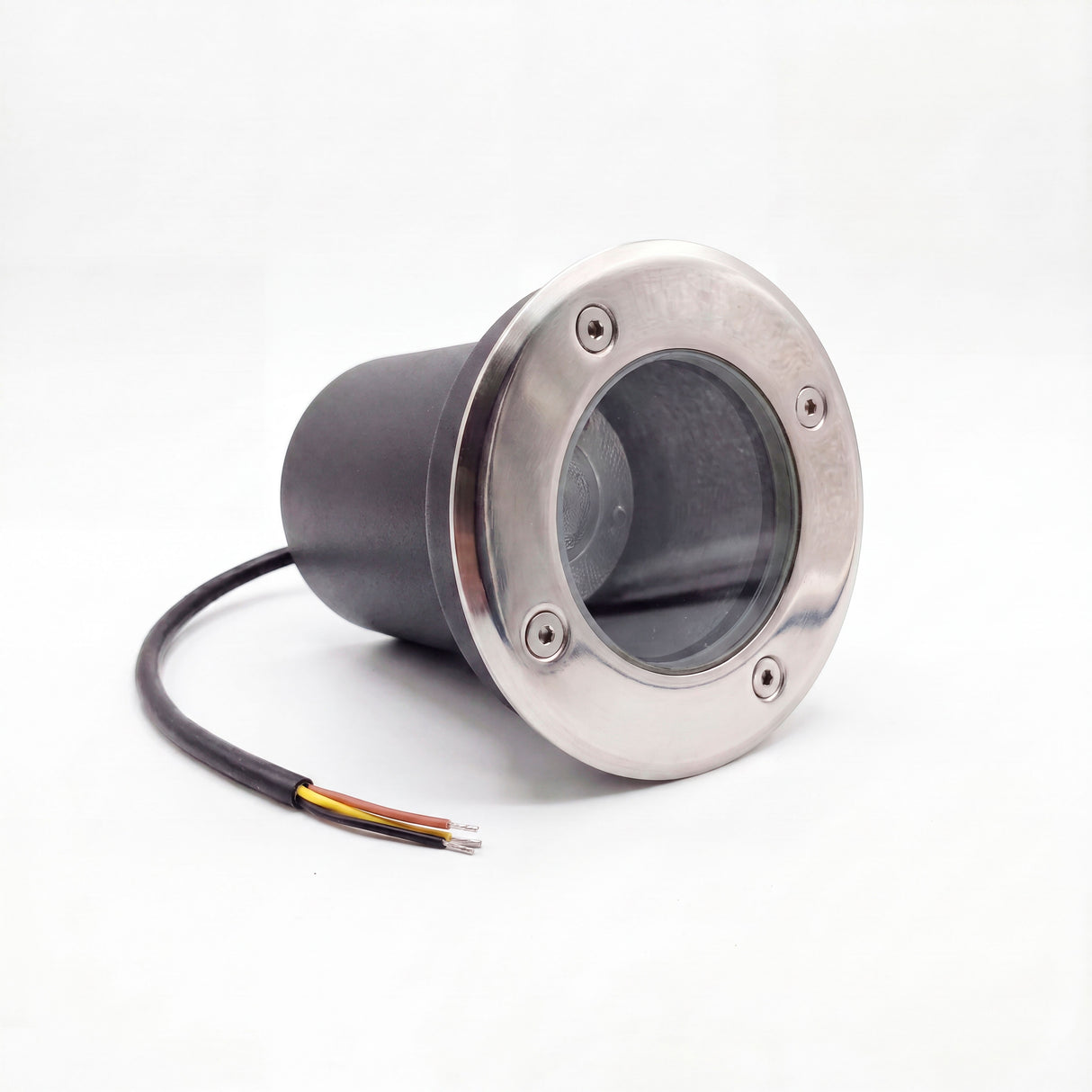 Proyector de piso con aro frontal de acero inoxidable y carcasa hermética negra para iluminación técnica exterior.