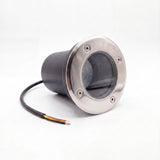 Proyector de piso con aro frontal de acero inoxidable y carcasa hermética negra para iluminación técnica exterior.