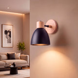 Luminaria de pared con pantalla esférica negra y florón de roble para ambientes minimalistas.