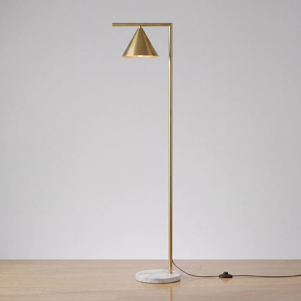 Luminaria de pie dorada con base de mármol para proyectos de interiorismo.