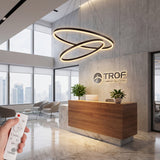 Vista frontal de lámpara triple aro negro con cables de suspensión invisibles sobre fondo neutro.