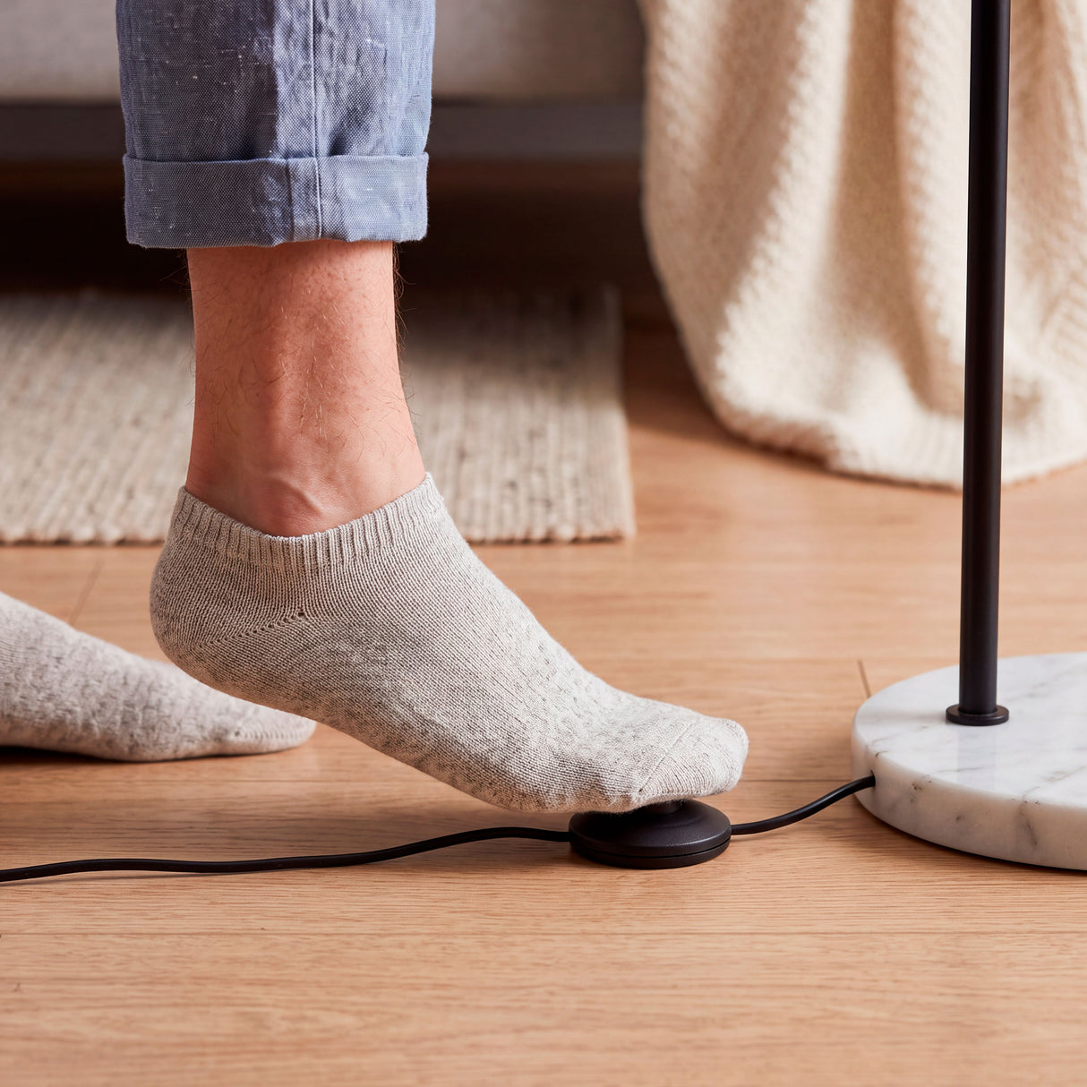 Interruptor ergonómico de pedal sobre cable para un encendido cómodo en arquitectura contemporánea.
