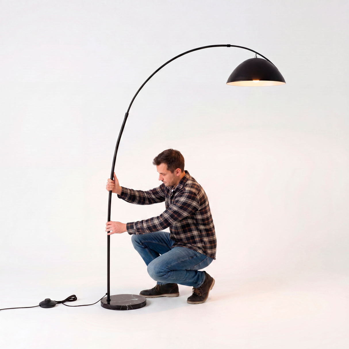Proceso técnico de ensamblaje y calibración de la curvatura metálica de una luminaria de pie de gama alta.