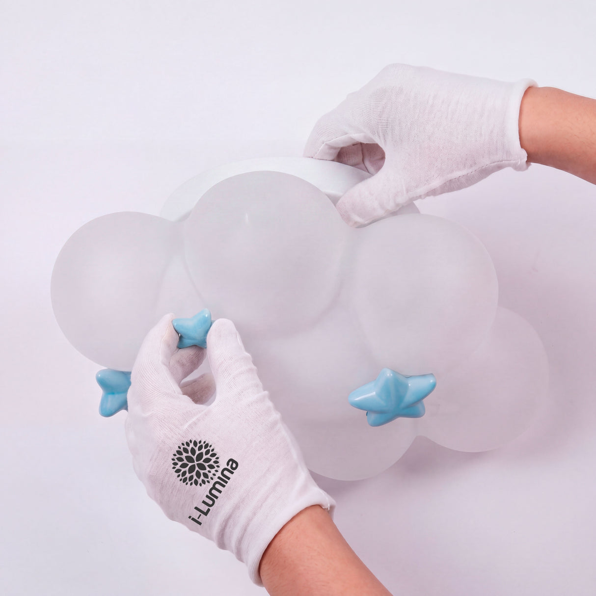 Especialista colocando los detalles de estrellas celestes en el plafón nube con guantes.