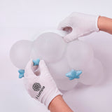 Especialista colocando los detalles de estrellas celestes en el plafón nube con guantes.