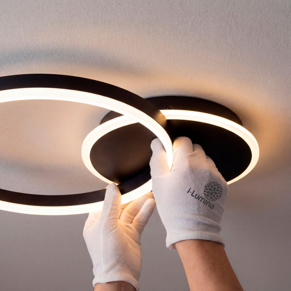 Instalación profesional de estructura circular negra con guantes de protección técnica.