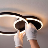 Instalación profesional de estructura circular negra con guantes de protección técnica.