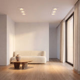 Ojo de buey de 3 luces empotrado al ras en el techo de una sala minimalista