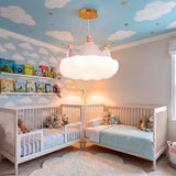 Lámpara Little King centrada en dormitorio con dos cunas y mural de globos aerostáticos.
