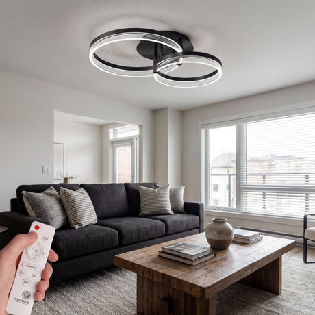 Lámpara de techo LED negra de doble círculo en un salón moderno con tonos grises.