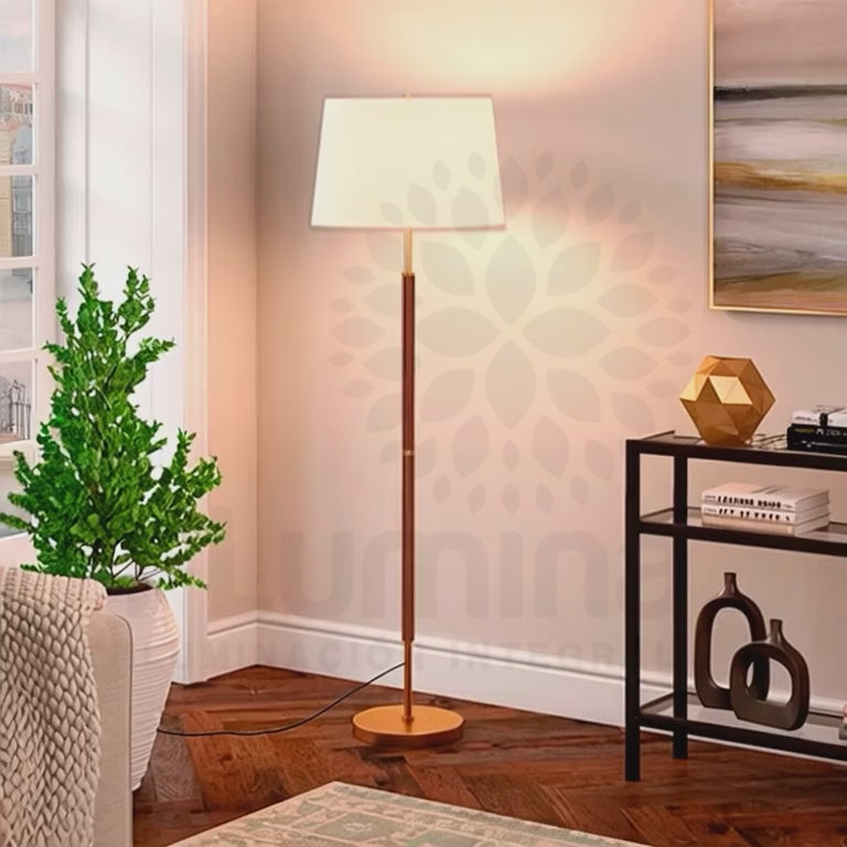 Lámpara de apoyo Jessica iluminando un rincón con consola de salón y planta de interior.