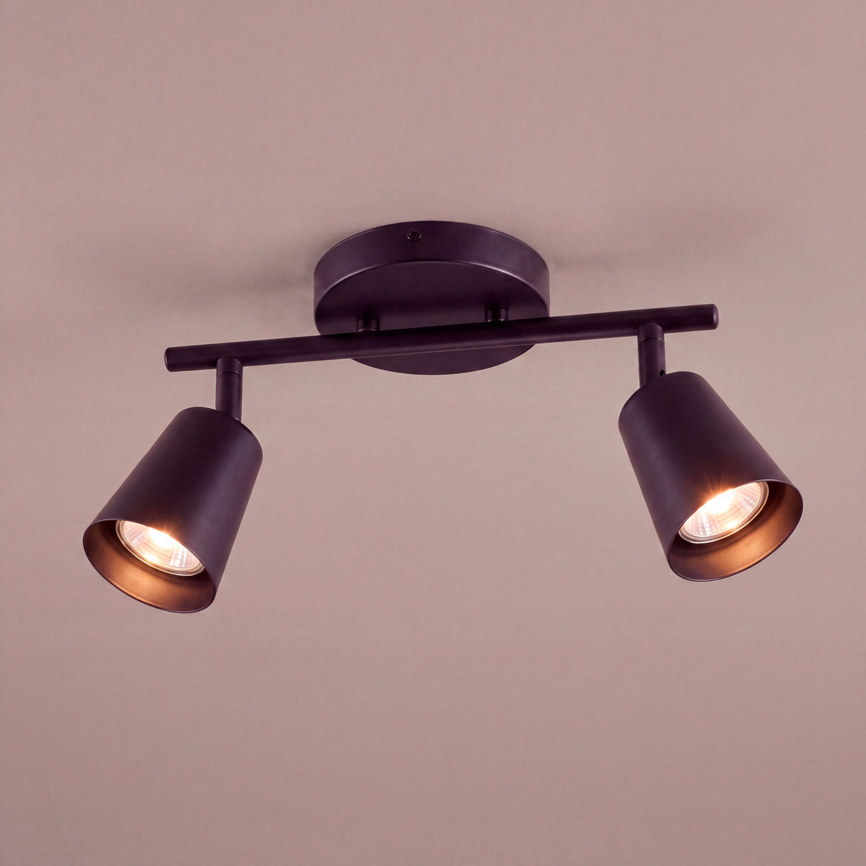 Proyección de dos haces de luz cálida desde el techo en espacio de interiorismo contemporáneo.